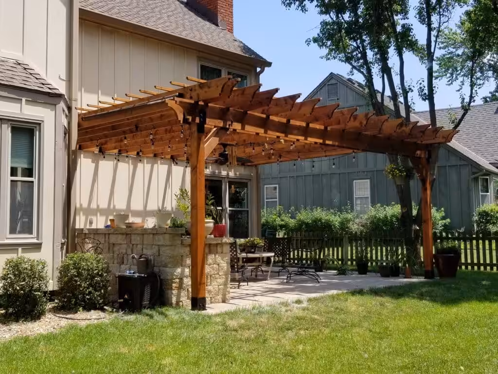 Stained cedar attached pergola with string lights built by Acumen Renovations in Kansas City